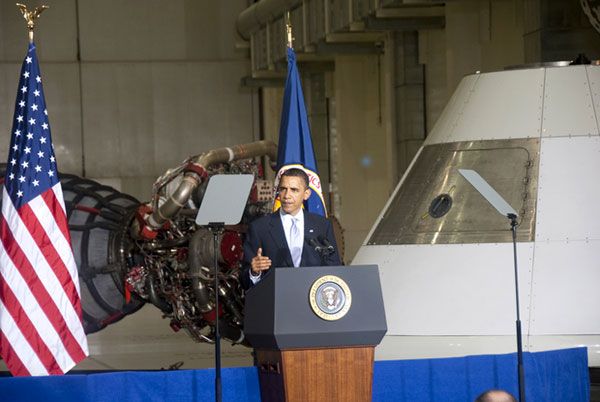 With a space shuttle main engine and an Orion capsule mock-up behind him, President Obama makes a speech about his plans for NASA at Kennedy Space Center, on April 15, 2010.