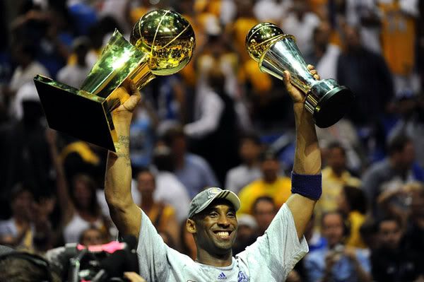 Kobe Bryant hoists up the NBA championship trophy and his Finals MVP trophy after he leads the Lakers to its 15th title, on June 14, 2009.