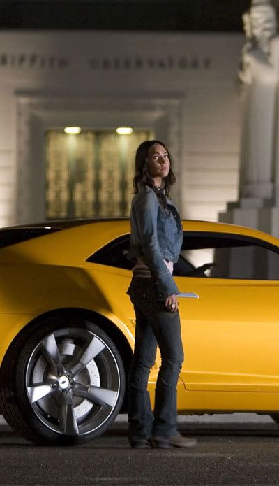 A production still of Megan Fox standing next to the 2009 Concept Camaro used for Bumblebee in TRANSFORMERS.