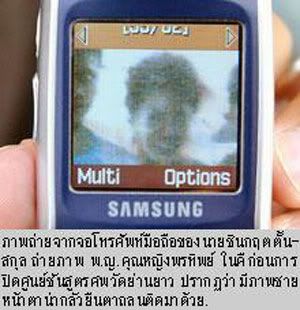 This is a Photoshopped pic assuming someone e-mailed this image to this dude’s cell phone.  If not, then how convenient that the ghost is smiling for the camera too!  Verizon LG should follow Samsung’s lead... They’d both be making billions if they could build camera phones that can photograph dead people!  Anyways, this photo actually appeared in a Thai newspaper.