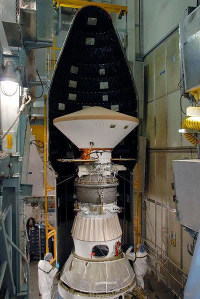 Technicians install a nose cone fairing around the Phoenix spacecraft after it is attached to its Delta II launch vehicle...in Pad 17-A at Cape Canaveral Air Force Station in Florida.