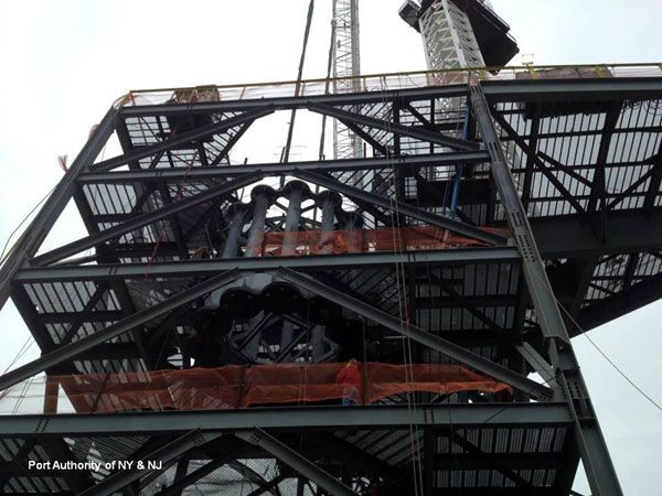 The first segment of the antenna spire is lowered through the middle of the scaffolding atop 1 WTC, on January 15, 2013.