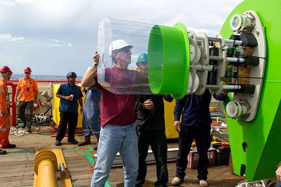 James Cameron fits a casing onto an instrument package atop the Deepsea Challenger submersible, which took him to the bottom of the Mariana's Trench on March 26, 2012 (Guam Time).