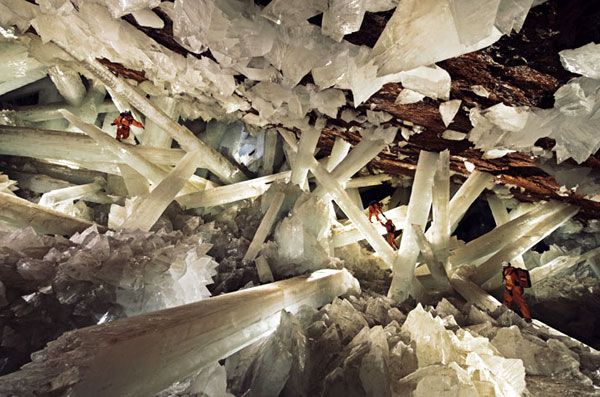 Clad in protective ice-cooled jumpsuits, explorers make their way through the Cave of Crystals in Mexico.
