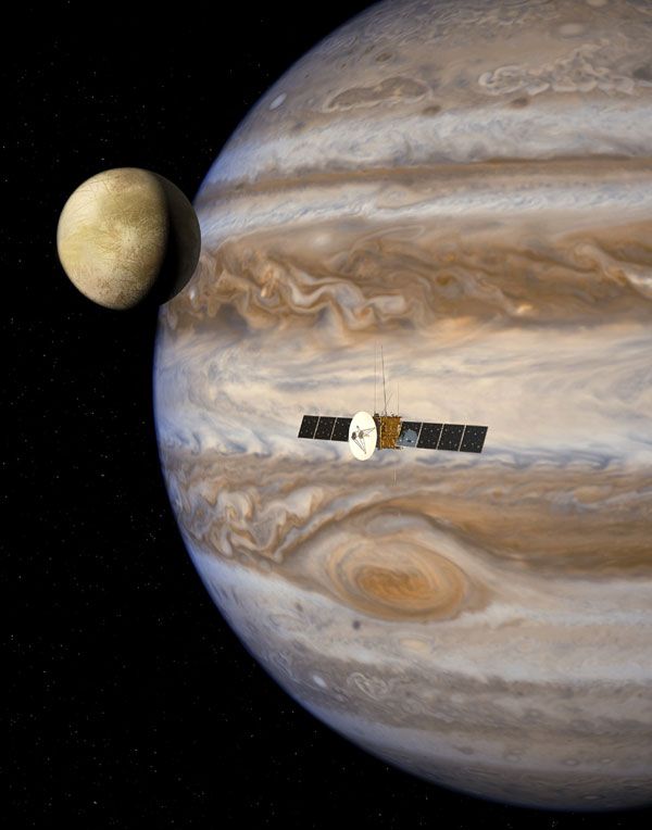 An artist's concept of ESA's JUICE spacecraft flying by Jupiter and one of its Galilean moons.