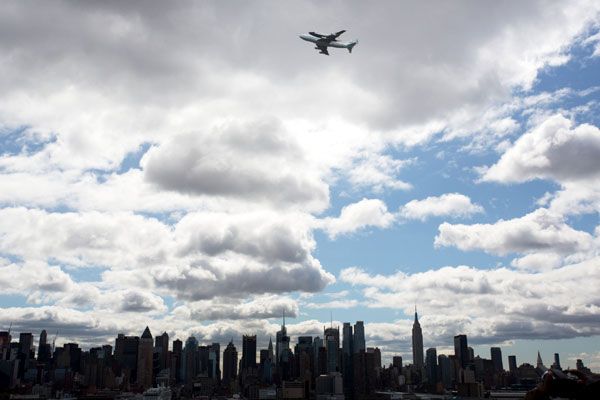 The shuttle Enterprise and NASA 905 fly over the New York City skyline on April 27, 2012.