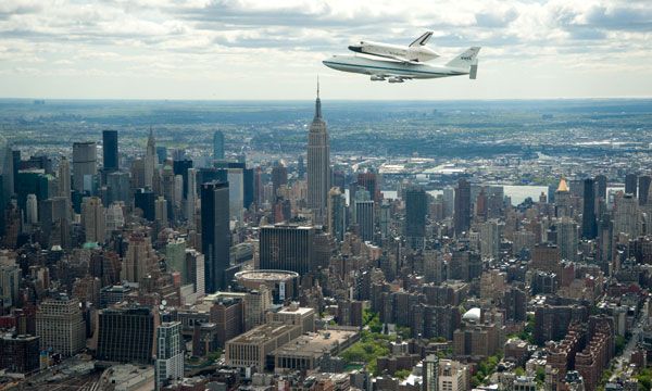 With the Empire State Building in the background, the shuttle Enterprise, mated atop NASA 905, flies above New York City on April 27, 2012.