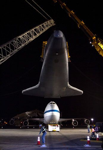 Enterprise is lowered towards the ground after demating from NASA 905 at JFK International Airport on May 12, 2012.