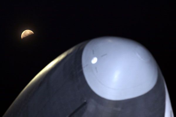 With the Moon in the background, Enterprise is lowered onto a transport vehicle (not shown) at JFK International Airport, on May 12, 2012.