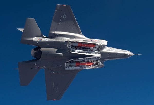 An F-35A Lightning II conducts a flight test with bombs and missiles aboard.
