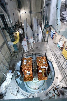 The GRAIL spacecraft are about to be encapsulated by the payload fairing (the two white half-cones in the background) of the Delta II rocket on August 24, 2011.