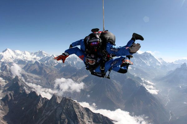 Tandem skydivers soar high above the Himalaya Mountains.