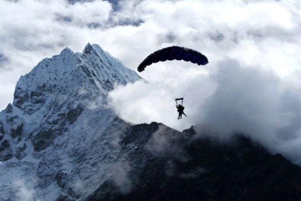 With Mt. Everest in the backdrop, the tandem skydivers are about to land at the drop zone located in the middle of the Himalaya Mountains.