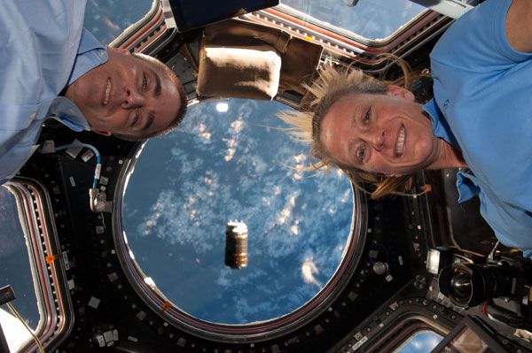 Space station crew members Chris Cassidy and Karen Nyberg pose for a snapshot while KOUNOTORI 4 is seen floating outside of the Cupola, on August 9, 2013. Space station crew members Chris Cassidy and Karen Nyberg pose for a snapshot while KOUNOTORI 4 is seen floating outside of the Cupola, on August 9, 2013.