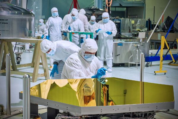 Technicians inspect one of the Jame Webb Space Telescope's (JWST) first two mirror segments in a clean room at the Goddard Space Flight Center in Maryland.