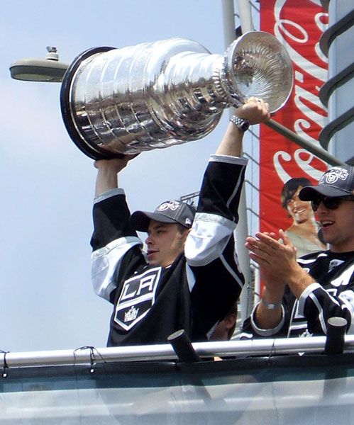 Los Angeles Kings captain Dustin Brown hoists up the Stanley Cup trophy during the Kings' championship parade in downtown L.A., on June 14, 2012.