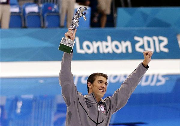 On August 4, 2012, Michael Phelps poses with a special trophy recognizing him as the greatest Olympian of all time...with 22 career medals.