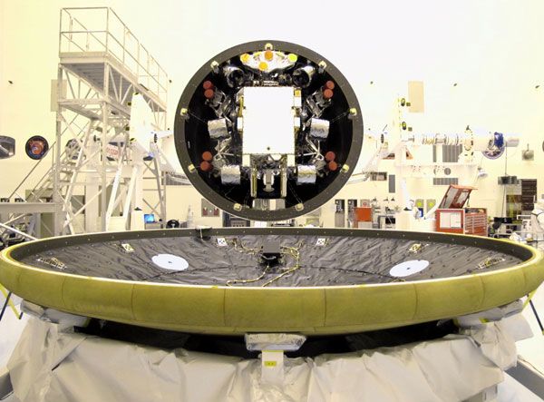 Attached to its backshell, the Curiosity Mars rover is about to be enclosed by the spacecraft's heat shield at NASA's Kennedy Space Center in Florida.