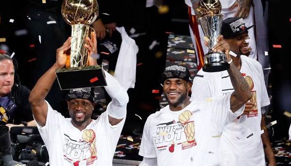 Dwyane Wade holds up the NBA championship trophy while LeBron James displays his NBA Finals MVP award after the Miami Heat defeats the San Antonio Spurs in Game 7 of the NBA Finals...on June 20, 2013.
