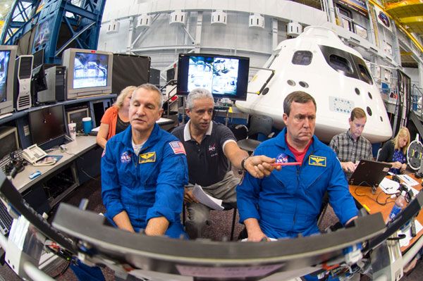 Astronauts Rick Linnehan and Mike Foreman work with simulation instructor Juan Garriga (center) to prepare for their first ascent simulation inside a mockup of the Orion vehicle at NASA's Johnson Space Center in Houston, Texas. Astronauts Rick Linnehan and Mike Foreman work with simulation instructor Juan Garriga (center) to prepare for their first ascent simulation inside a mockup of the Orion vehicle at NASA's Johnson Space Center in Houston, Texas.