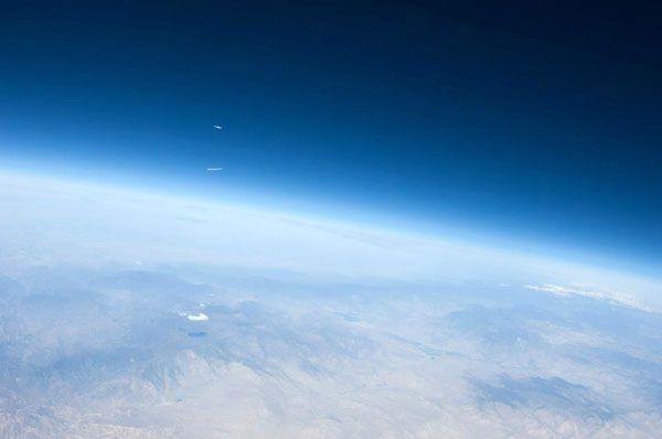 Photographed from afar, oxidizer shoots out from SpaceShipTwo's rocket nozzle after she is released from White Knight II for another glide test on April 12, 2013. Photographed from afar, oxidizer shoots out from SpaceShipTwo's rocket nozzle after she is released from White Knight II for another glide test on April 12, 2013.