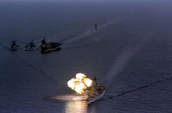 Sailing with the aircraft carrier USS Saratoga's battle group, the USS Iowa fires her guns during a 1987 naval exercise.
