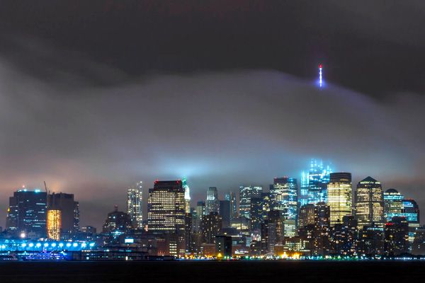 The 1 WTC's antenna spire is visible above a layer of fog that enshrouds New York City.