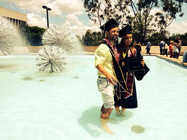 A graduate poses for a photo inside the Lyman Lough Fountain outside of CSULB's Brotman Hall, on May 20, 2014.