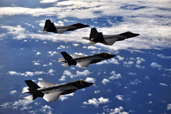 A pair of F-22 Raptors and two F-35 Lightning IIs fly in formation for a training mission.