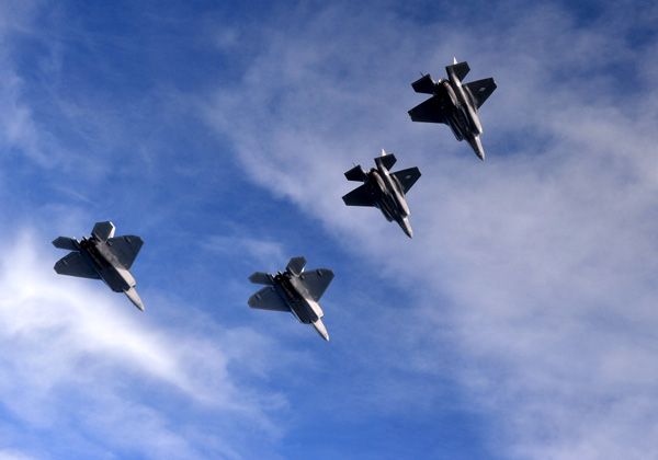 A pair of F-22 Raptors and two F-35 Lightning IIs fly in formation for a training mission.