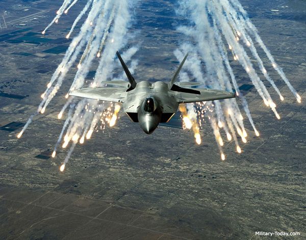 An F-22 Raptor fires flares while in flight.