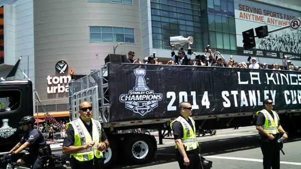 Los Angeles Kings center Anze Kopitar hoists up the Stanley Cup trophy as the flatbed truck carrying the 2014 National Hockey League (NHL) champions approaches STAPLES Center during their victory parade...on June 16, 2014.