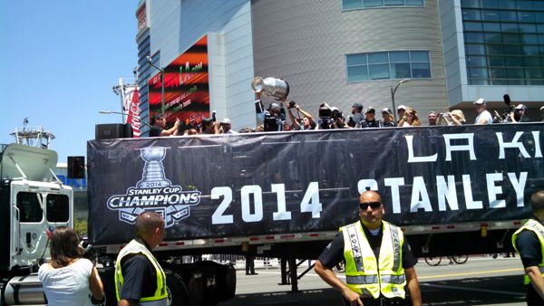 Los Angeles Kings center Anze Kopitar hoists up the Stanley Cup trophy as the flatbed truck carrying the 2014 NHL champions approaches STAPLES Center during their victory parade...on June 16, 2014.