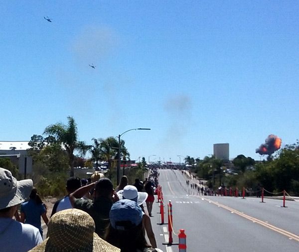 People head towards the main airfield at Marine Corps Air Station (MCAS) Miramar as two AH-1 Cobra attack helicopters approach an explosion in the distance...on September 24, 2016.