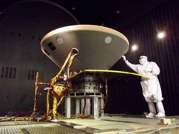 An engineer inspects the heat shield and aeroshell that enshroud NASA's InSight Mars lander at the Lockheed Martin facility near Denver, Colorado.