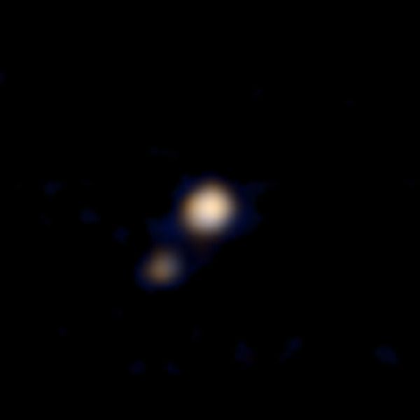 A colored image of the dwarf planet Pluto and its largest moon, Charon...taken from a distance of 71 million miles (115 million kilometers) by NASA's New Horizons spacecraft on April 9, 2015.