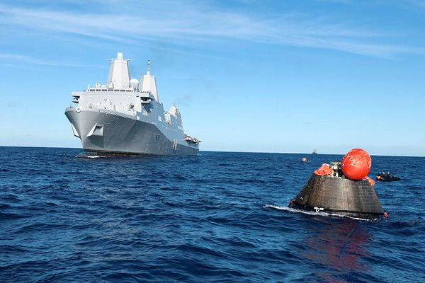 The USS Anchorage approaches the Orion EFT-1 spacecraft in preparation for the capsule being towed back to the ship for securing aboard the vessel, on December 5, 2014.