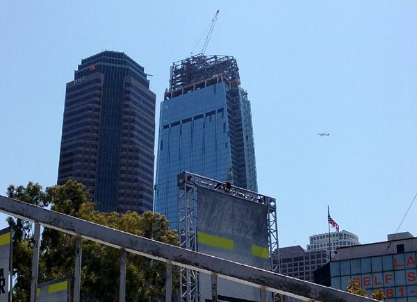 An airliner sails through clear blue skies above the Wilshire Grand Center on August 23, 2016.