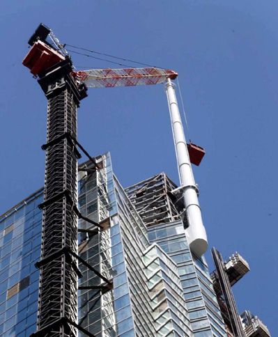 Construction workers inside a steel cage put finishing touches on the spire after its final segment was installed atop the Wilshire Grand Center...on September 3, 2016.