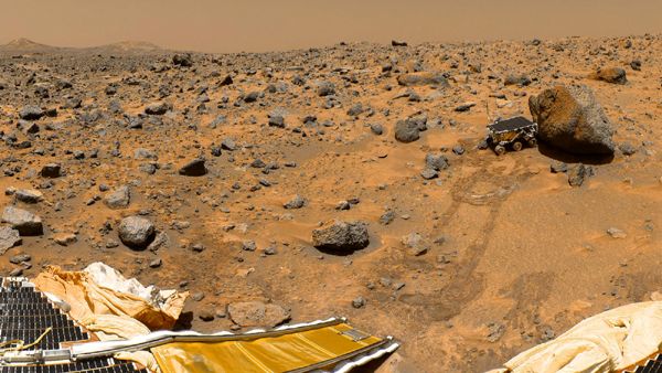 A classic photo of NASA's Sojourner rover studying a large rock near the Mars Pathfinder lander in the summer of 1997.