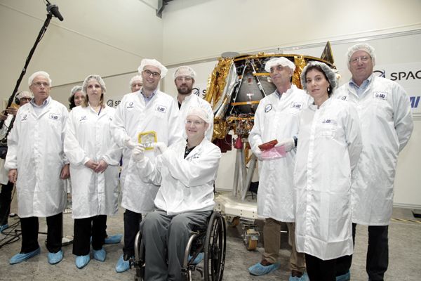 A SpaceIL official displays a memento prior to its installation aboard Israel's Beresheet lunar lander.