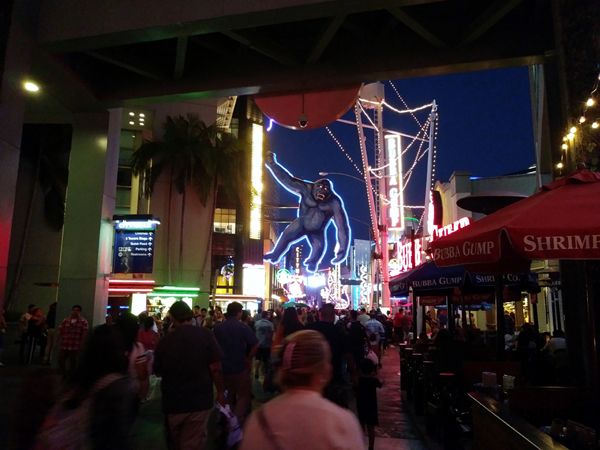 A crowd of people walk towards a KING KONG neon sign at Universal CityWalk in North Hollywood...on August 26, 2018.