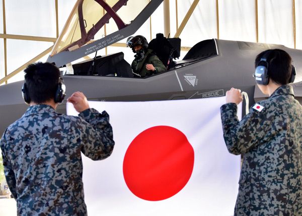 At Luke Air Force Base in Arizona, Japan Air Self-Defense Force (JASDF) pilot Lt. Col. Nakano sits inside the cockpit of an F-35A Lightning II as JASDF maintainers display a Japanese flag...on February 7, 2017.