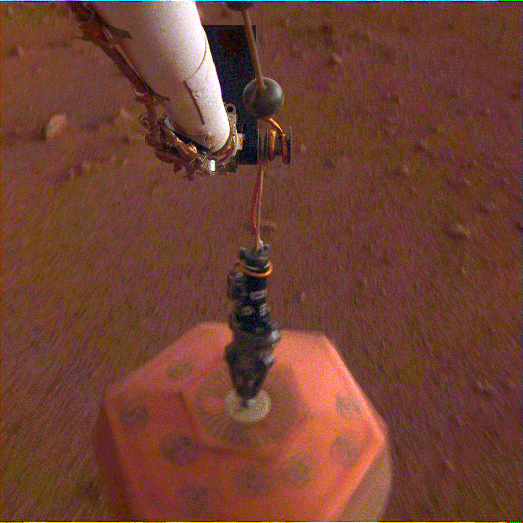 An animated GIF comprised of images taken by NASA's InSight lander (using its Instrument Deployment Camera) as it placed a seismometer on the surface of Mars...on December 19, 2018.
