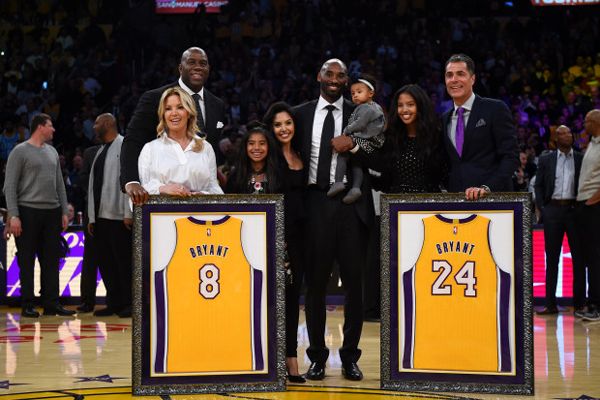 Kobe Bryant poses with his family as well as Jeanie Buss, Magic Johnson and former agent Rob Pelinka during Bryant's jersey retirement ceremony at STAPLES Center...on December 18, 2017.