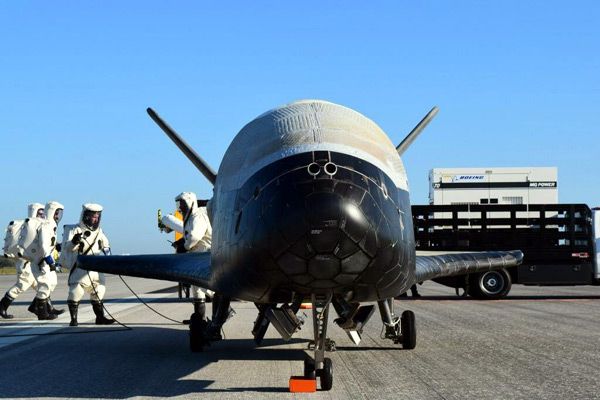 Technicians inspect the X-37B Orbital Test Vehicle after it landed at NASA's Kennedy Space Center in Florida following a 718-day mission in space...on May 7, 2017.