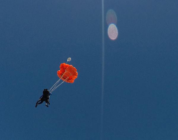 My videographer continues to film me and my tandem instructor as she falls away from us after our parachute deploys above the ground at Oceanside, California...on October 4, 2018.