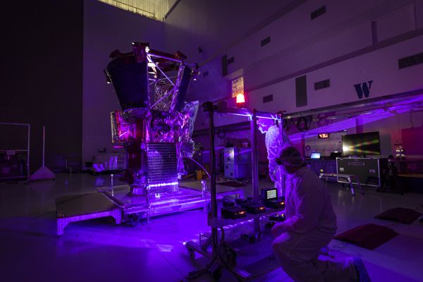 Parker Solar Probe team engineers use a laser to illuminate the cells on the twin solar arrays installed aboard the spacecraft on May 31, 2018...at Astrotech Space Operations in Titusville, Florida.