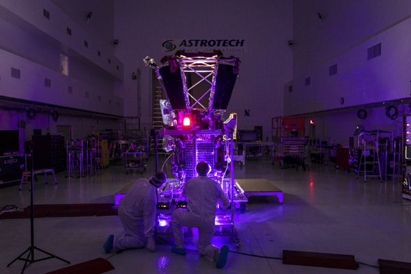 Parker Solar Probe team engineers use a laser to illuminate the cells on the twin solar arrays installed aboard the spacecraft on May 31, 2018...at Astrotech Space Operations in Titusville, Florida.