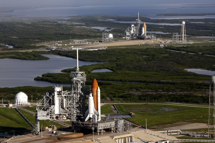 Space shuttle Atlantis stands ready for launch at Kennedy Space Center's Pad 39A in the foreground, while in the background, at Pad 39B 1.6 miles away, Endeavour begins preps for a potential rescue mission to Atlantis if she is found damaged during next month's flight to the Hubble Space Telescope.